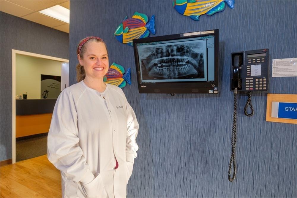 Smiling Doctor standing besides LCD