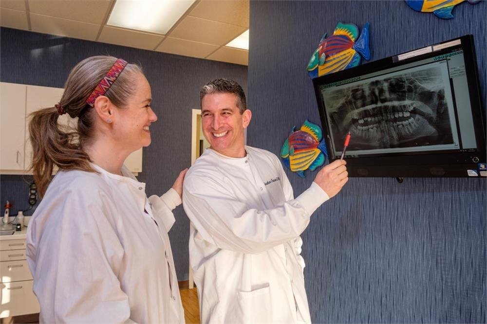 smiling Doctors looking at X-ray on screen
