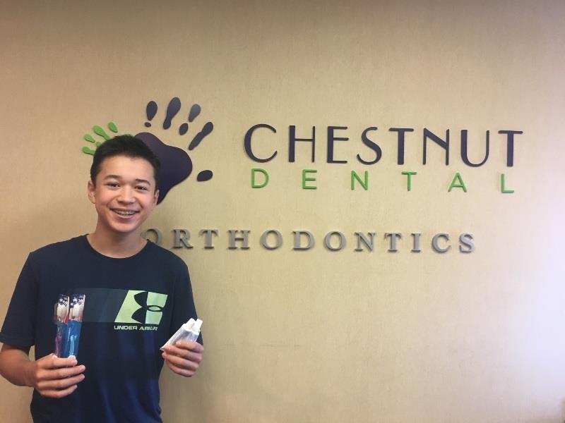 man standing infront of chestnut dental logo